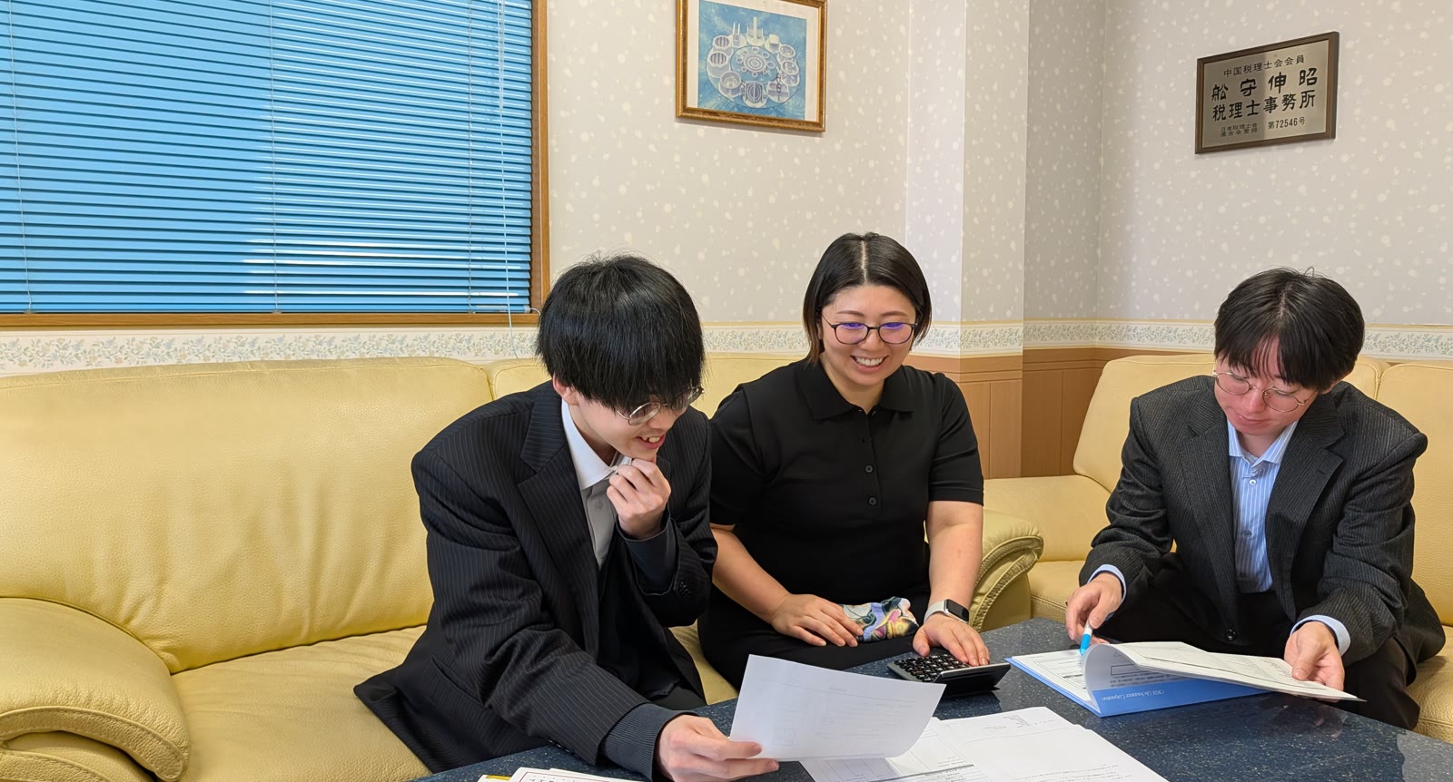 舩守会計事務所で相談しながら仕事を進める3名のスタッフ