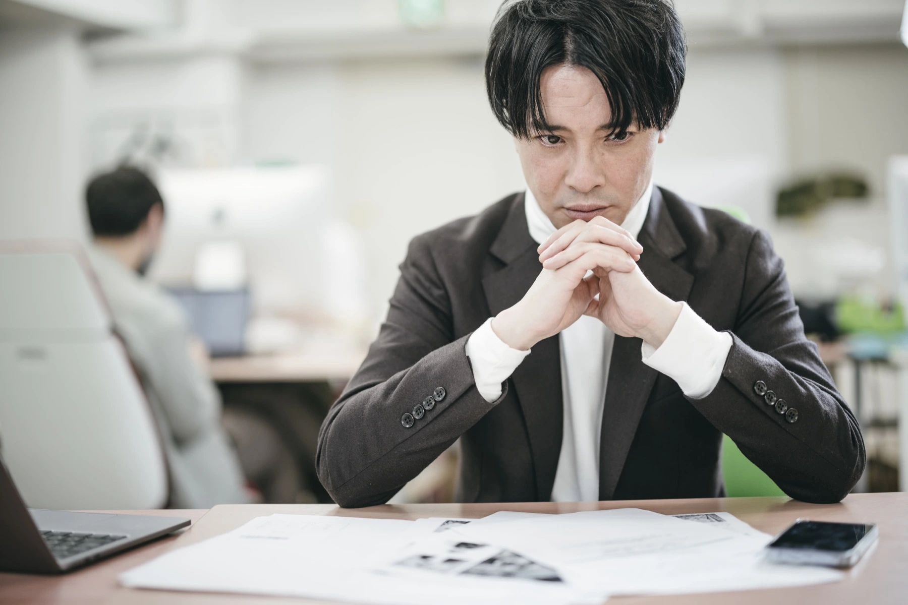 経営資料を前に今後の方針を考える法人経営者